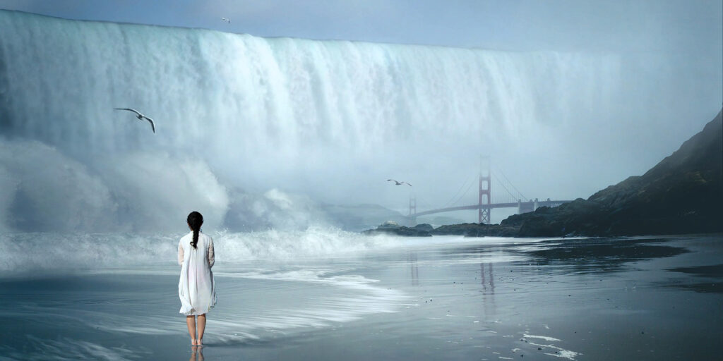 Photo of woman in front of huge waterfall that overflows land