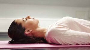 Vrouw liggend op de grond in diepe ontspanning als beeld van de Light Body Kwantum Hypnose