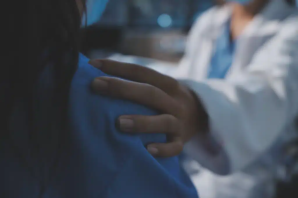 Medische hypnose toepassen met visual van arts die empathisch hand op schouder legt.